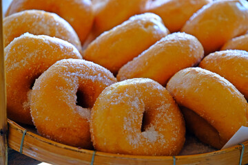 Homemade sugar donuts in basket ready to serve.
