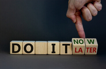 Do it now symbol. Businessman hand turns cubes and changes words 'do it later' to 'do it now'. Beautiful grey background. Business and do it now concept. Copy space.