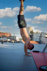 Sporty young man working out, doing handstand