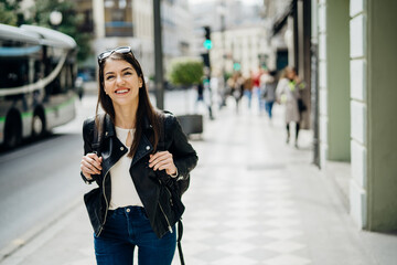Cheerful happy woman exploring the centre of Granada.Visiting famous landmarks and places.Travelling to Europe. Walking tour in Madrid.Backpack tourist Spain vacation experience.Student in Andalusia