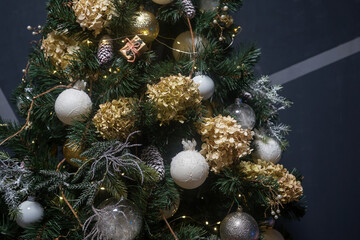 Obraz na płótnie Canvas stylish big lush tree decorated with new year toys and decor on gray background 