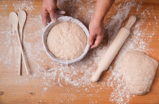 A Top View Of Hands Putting Sourdough In A Form