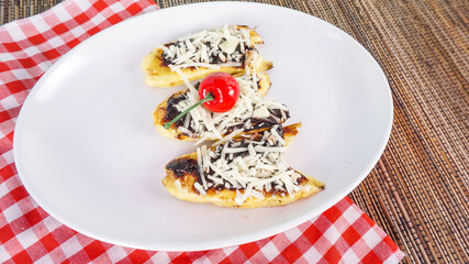 Delicious roasted banana with chocolate cheese on the white plate