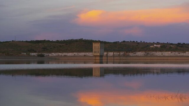 Lucefecit Dam in Terena with reflection on the lake reservoir at sunset, in Portugal