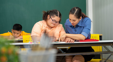 Asian Autism children with disability kid on wheelchair in special classroom with teacher. 