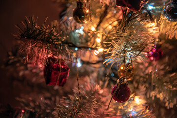 Festive lights of a Christmas tree, colorful balls on the branches