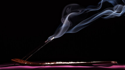 smoke rising from incense sticks placed on the base