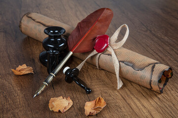 Photograph of a fountain pen with an old inkwell and several differently shaped nibs on papyrus...