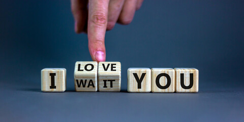 I love you symbol. Hand turns cubes and changes the expression 'I wait you' to 'I love you'. Beautiful grey background, copy space. Psychological and i love you concept.