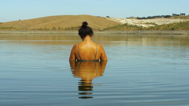 Caucasian woman swimming during summer in Lucefecit Dam lake reservoir in Terena Portugal