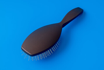 The massage comb with metal teeth on a blue background