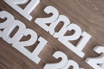 White 2021 new year numbers on a wooden background