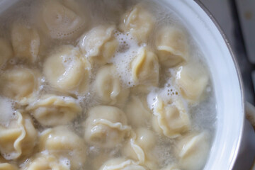 Dumplings are cooked in a pot in the kitchen. Cooking dumplings at home.