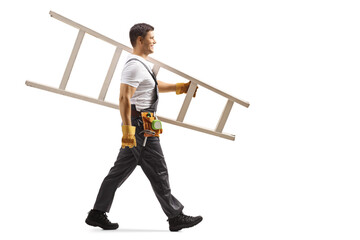 Full length profile shot of a repairman in uniform walking and carrying a white ladder © Ljupco Smokovski