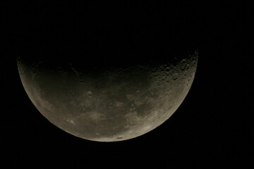 Astrophotography of the first quarter Moon taken with a camera fastened on a telescope
