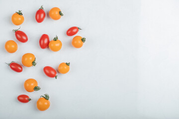 Close up photo of pile of cherry tomatoes on white background