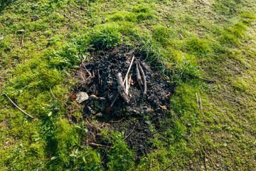Obraz premium Lagerfeuer, Feuerstelle mit Gestell aus Ästen und Steinen