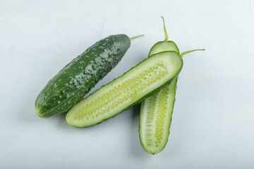 Close-up of fresh cucumbers and slices isolated on white background.