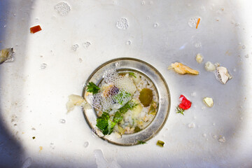 Close up on dirty clogging kitchen sink drain with food particles