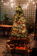 Golden star on the Christmas tree, Christmas tree decoration with Golden balls garland, green spruce in the interior of the apartment, preparation for the Christmas holiday