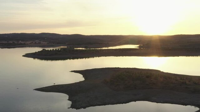 Drone aerial panorama of a dam lake reservoir landscape with olive and cork trees in Alentejo Terena, Portugal