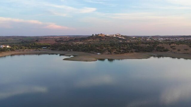 Drone aerial view of a dam lake reservoir landscape with Terena village on the background, in Portugal