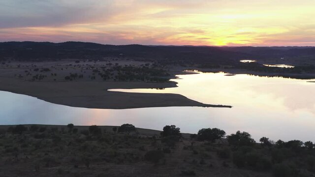 Drone aerial panorama of a dam lake reservoir landscape with olive and cork trees in Alentejo Terena, Portugal