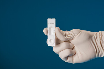 Doctor holding a test kit for viral disease tests with the COVID-19 SARS-CoV-2 laboratory card kit...