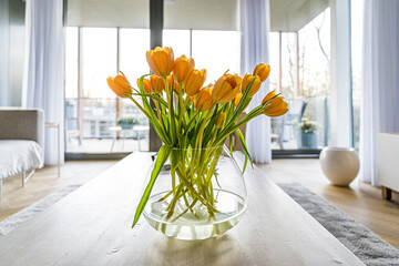 Yellow tulips in a vase on the table in a modern interior