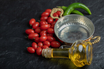 Organic Cherry tomatoes with bottle of oil and frying pan