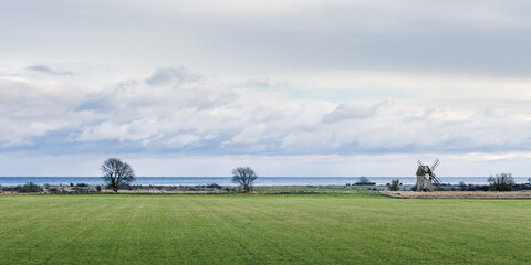 Fototapeta na wymiar old windmill on coastal meadow
