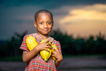image of cheerful  african kid, with harvested cocoa