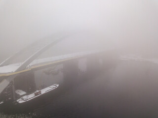 Aerial drone view. A bridge under construction in Kiev in the morning fog.