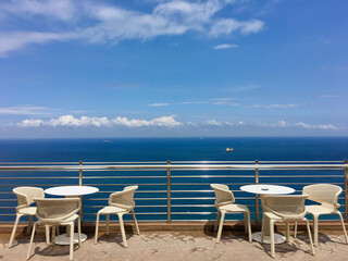 Terrace with a view on sea. Umbrellas and lounge chair in a sunlight.