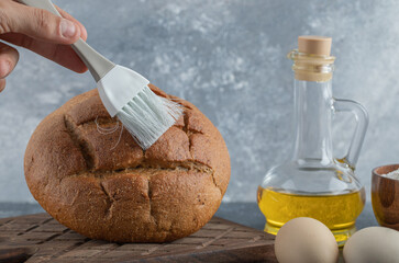 Man covering his rye bread with oil