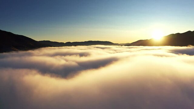 Sunrise over mountain hils covered with gray mist, Aerial UHD 4K drone realtime video, shot in 10bit HLG and colorized
