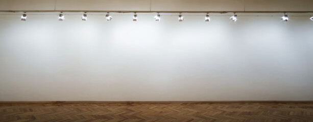 Interior of a empty white wall with spot lights at art gallery - obrazy, fototapety, plakaty