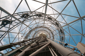 Big metal architectural construction on sky background, view from the bottom