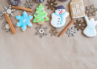 Gingerbread painted colored gingerbread cookies and spices and snowflakes on a craft background close-up. Christmas celebration concept. New Year's food. Copy space
