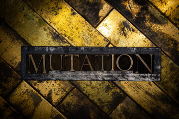 Photo of real authentic typeset letters forming Mutation text on vintage textured grunge copper and black background 