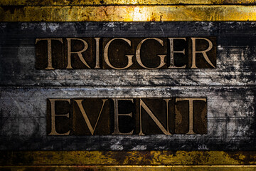 Trigger Event text formed with real authentic typeset letters on vintage textured grunge copper background