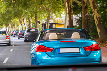Blue cool cabriolet car drives through Bremen in summer.