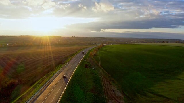 Summer landscape with green field with traffic on the road in Ukraine. Aerial UHD 4K drone realtime video, shot in 10bit HLG and colorized