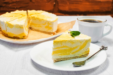 Slice of cheesecake with lemon filling decorated with mint.