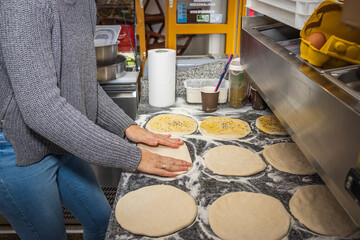 A girl making doner buns in a local pizza and gyros restaurant