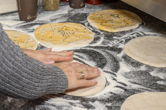 A girl making doner buns in a local pizza and gyros restaurant