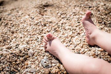 Children's feet in the sand on the beach. Child feet in the sand on the beach. A little girl's barefoot feet in the sand.