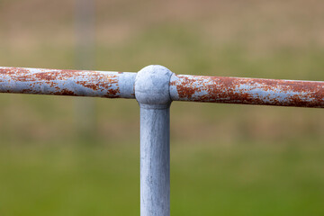 A rusty steel fence post and hand rail