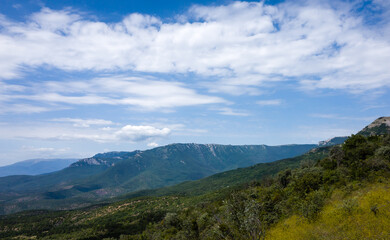 View of the mountains covered with green forest, descending to the right to the sea.