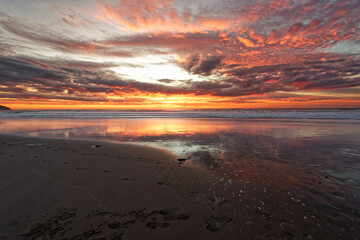 Golden sunrise across the ocean on a beach - 401572978
